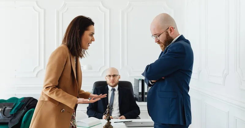 Business professionals engaged in a serious office meeting discussing legal matters.