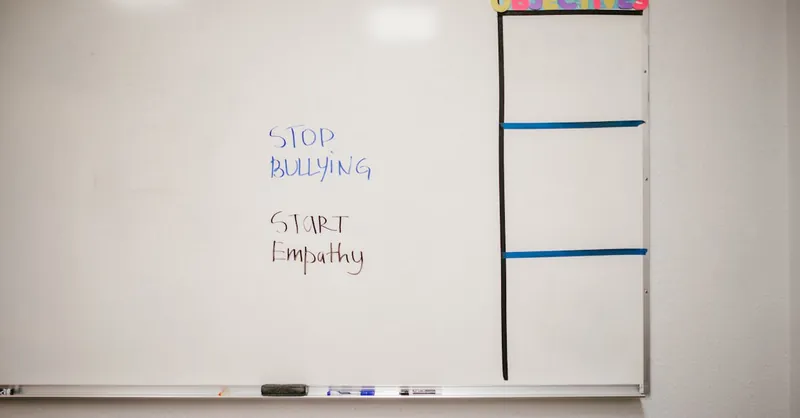 Whiteboard with messages to stop bullying and start empathy for school awareness.
