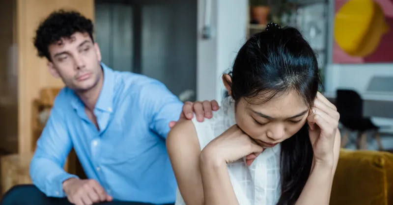 Man comforting a woman in a living room, showcasing empathy and support.