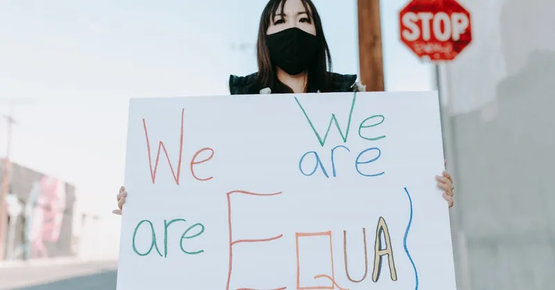 Woman displaying an equality sign during a peaceful street protest, advocating for justice and democracy.