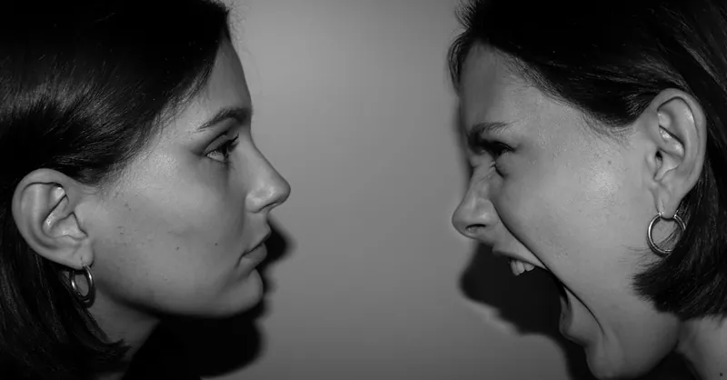 Two women face each other in high contrast, one shouting, depicting raw emotion.
