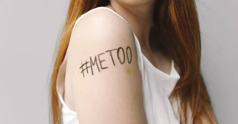 Close-up of a woman with #MeToo written on her arm, symbolizing empowerment and solidarity.