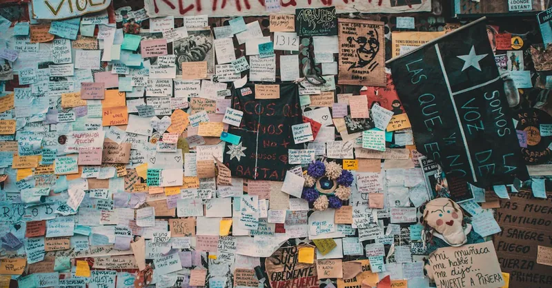 Colorful protest wall with messages in Santiago, Chile, expressing social and political sentiments.