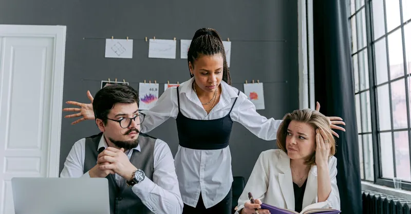 A diverse group of employees experiencing conflict at the office, depicting frustration and gesturing.