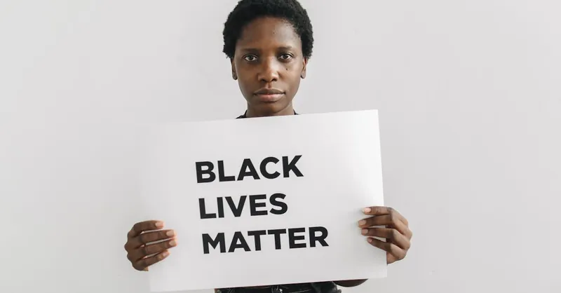 A woman holding a Black Lives Matter sign, advocating for social justice and equality.