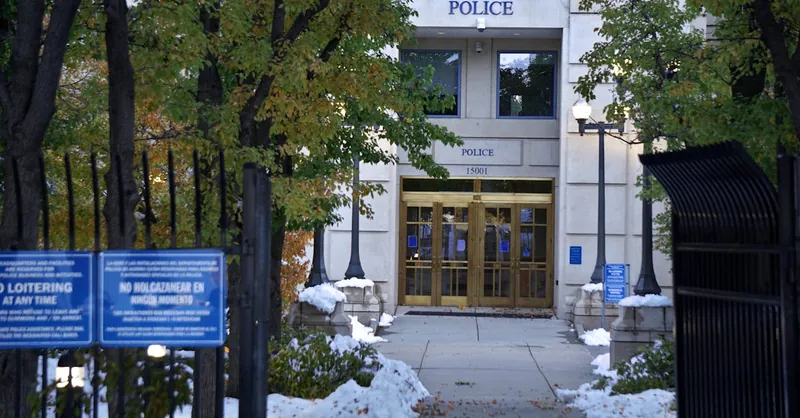 Police station entrance with snow on the ground and no loitering signs.