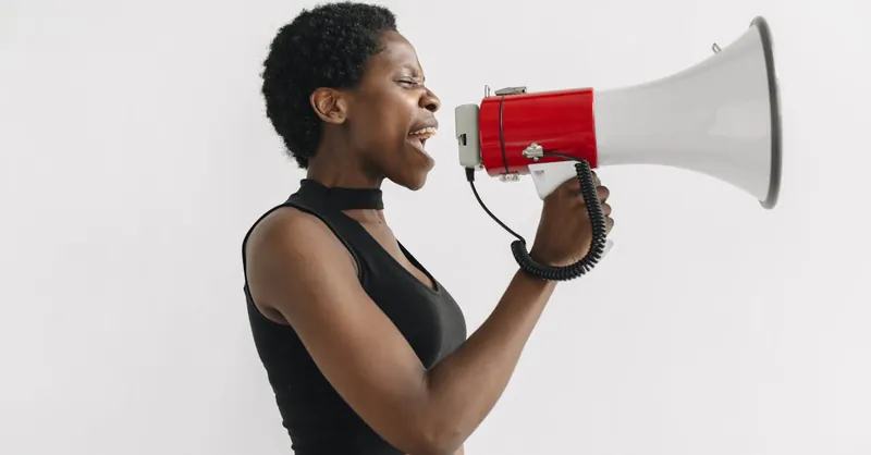 African American woman using a megaphone to protest, symbolizing activism and empowerment.