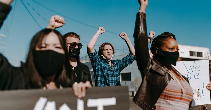 A diverse group of activists protesting peacefully outdoors, showing unity and solidarity.