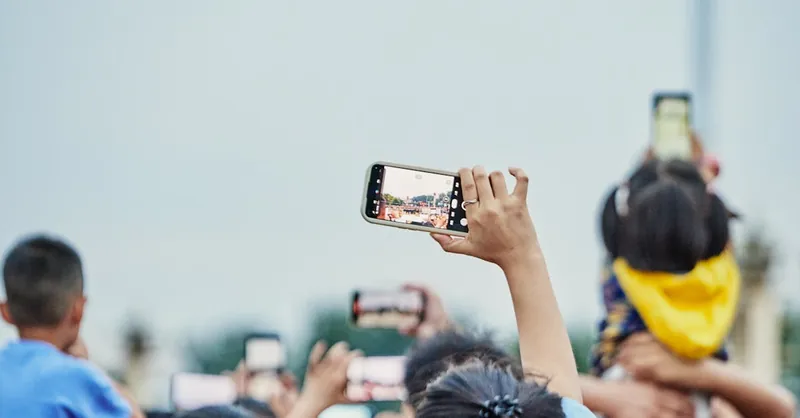 A lively crowd capturing an event on smartphones, showcasing modern digital engagement.