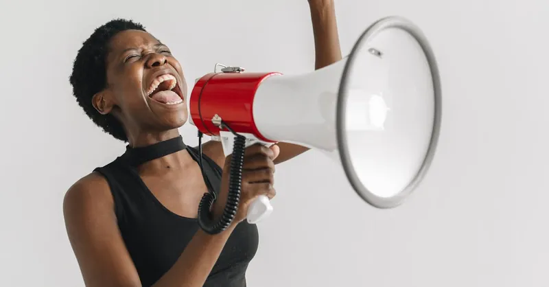 A passionate woman shouting into a megaphone, expressing empowerment and activism.